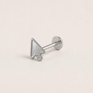 May include: A silver-toned labret stud body jewelry piece featuring a flat, textured computer mouse cursor arrow design at the front. The piece includes a straight post and a circular flat back disc, crafted from a metallic material with a matte finish.