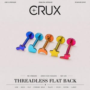 May include: Five threadless flat back piercing studs with iridescent rainbow metal finishes. The shapes include a cross, heart, crescent moon, star, and lightning bolt. The text CRUX JEWELRY and THREADLESS FLAT BACK is visible on the image.