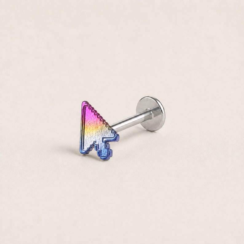 May include: A labret body jewelry piece featuring a computer mouse cursor shape as the decorative top. The cursor has a metallic gradient finish transitioning from purple to yellow and blue. It is attached to a straight silver-toned post.