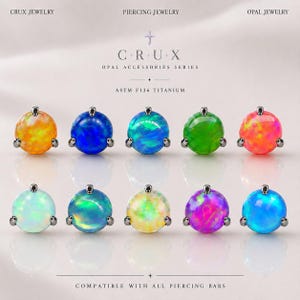 May include: Ten round opal piercing jewelry attachments arranged in two rows. Each stone is set in a dark metal prong setting. Text reads: CRUX JEWELRY, PIERCING JEWELRY, OPAL JEWELRY, C+R+U+X, OPAL ACCESSORIES SERIES, ASTM F136 TITANIUM, COMPATIBLE WITH ALL PIERCING BARS.