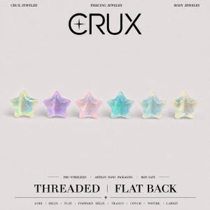 May include: Six star-shaped body jewelry studs in iridescent pastel colors arranged in a horizontal row. The text CRUX PIERCING JEWELRY BODY JEWELRY appears at the top, and THREADED FLAT BACK with piercing locations at the bottom.