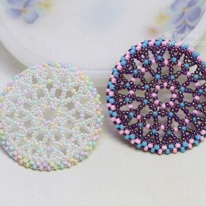 Olwyn wheel pendants in two colors. One is white and mix pastel. The other is purple, pink and blue.