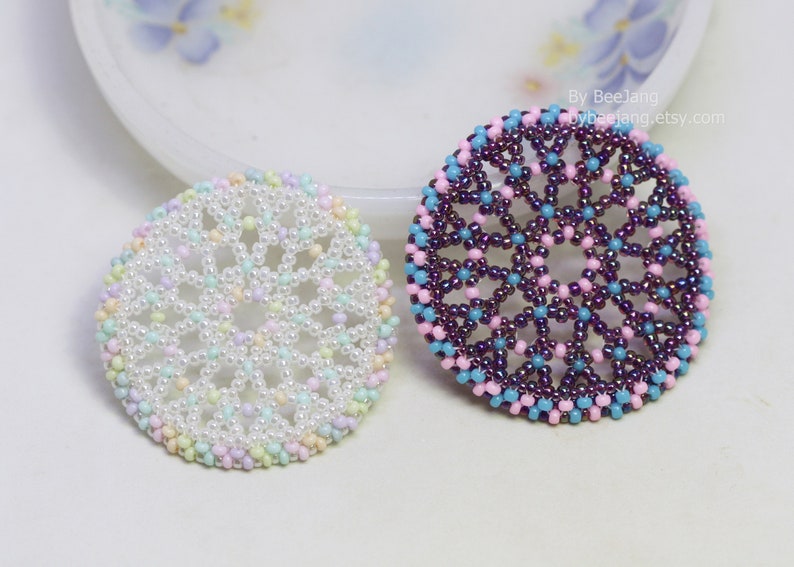 Olwyn wheel pendants in two colors. One is white and mix pastel. The other is purple, pink and blue.