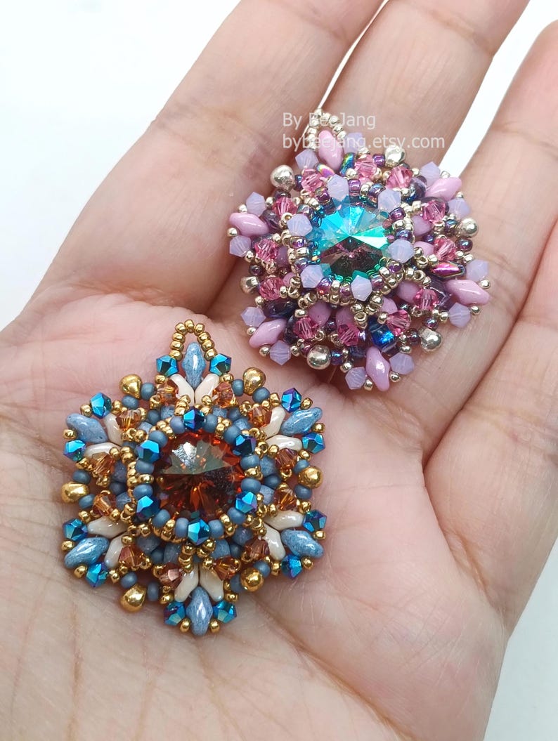 Ceres pendants in two colors. One is in copper, blue and beige. The other is in pink, purple and silver.