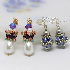 May include: A pair of pearl and bead earrings. One pair features a purple, blue, and gold bead design with a large pearl drop. The other pair features a blue and silver bead design. The text "By Bee Jang bybeejangretsy.com" is visible in the image.