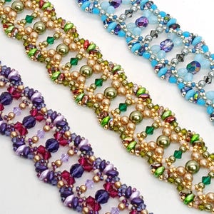 Puede incluir: Primer plano de tres pulseras de cuentas en tonos azules, verdes y morados. Las pulseras presentan intrincados patrones con varios tama&ntilde;os y colores de cuentas, incluyendo cuentas doradas, verdes, moradas y transparentes. Las pulseras se exhiben sobre una superficie blanca.