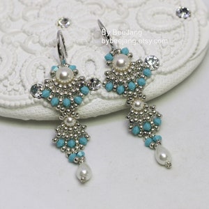 May include: A pair of silver dangle earrings with turquoise and white beads. The earrings are made with small beads and have a teardrop shape.