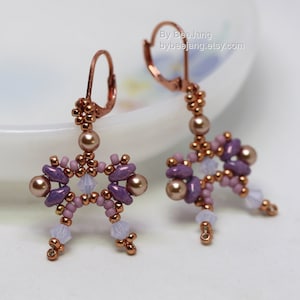 May include: A pair of copper-toned earrings with a star-shaped design. The earrings are made with purple, pink, and white beads.