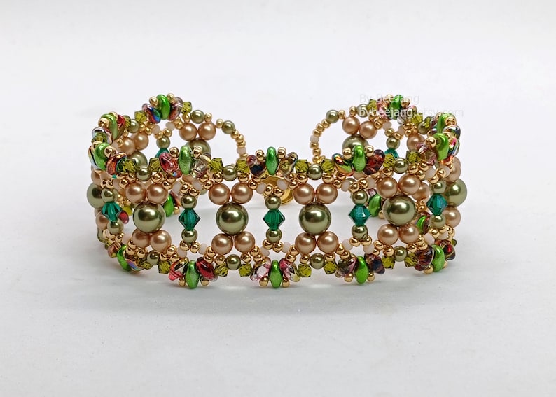 Puede incluir: Una pulsera de cuentas con un marco de metal dorado, cuentas verde oliva, marr&oacute;n claro y verde. La pulsera tiene un dise&ntilde;o sim&eacute;trico con cuentas redondas y facetadas, creando un aspecto texturizado.
