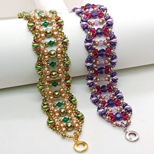 Puede incluir: Dos pulseras de cuentas. Una es dorada, verde y color perla, con un cierre dorado. La otra es morada, rosa y color perla, con un cierre plateado. Ambas pulseras tienen un patr&oacute;n repetitivo de cuentas.