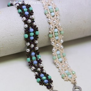 May include: Two beaded bracelets with a white background. The bracelet on the left has brown, blue, and green beads. The bracelet on the right has white, blue, and green beads. Both bracelets have silver clasps.