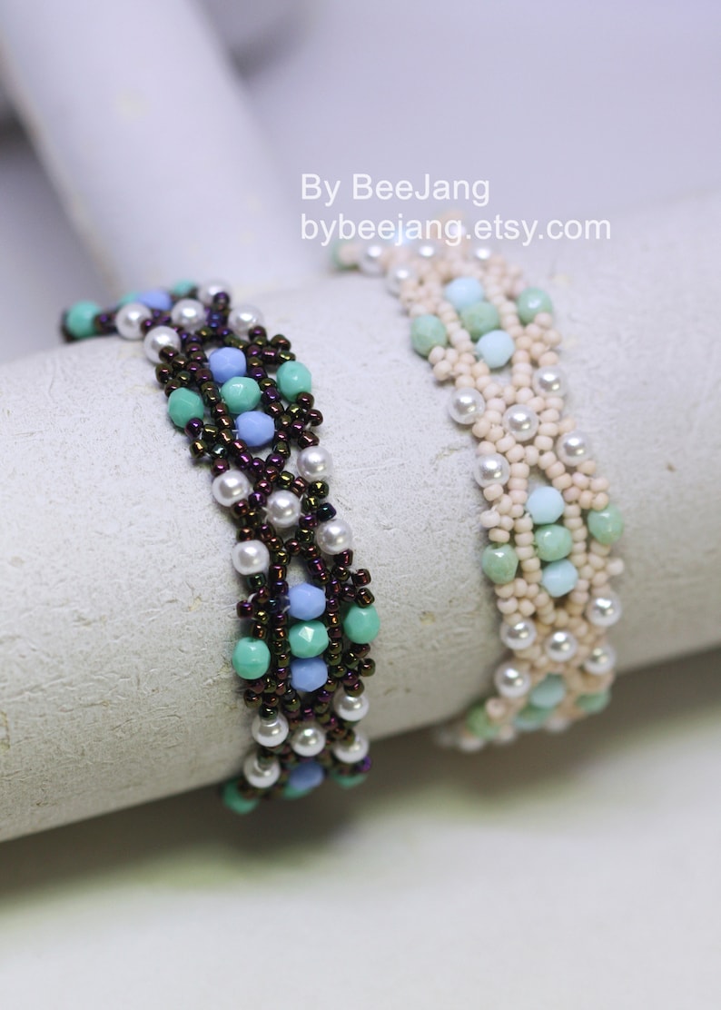 May include: Two beaded bracelets with a woven design. One bracelet is made with white, light blue, and green beads. The other bracelet is made with white, light blue, and dark brown beads. The bracelets are on a white surface. By BeeJang bybeejang.etsy.com