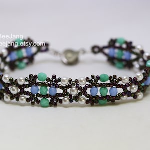 May include: A beaded bracelet with a brown, blue, green, and white color scheme. The bracelet has a clasp closure.