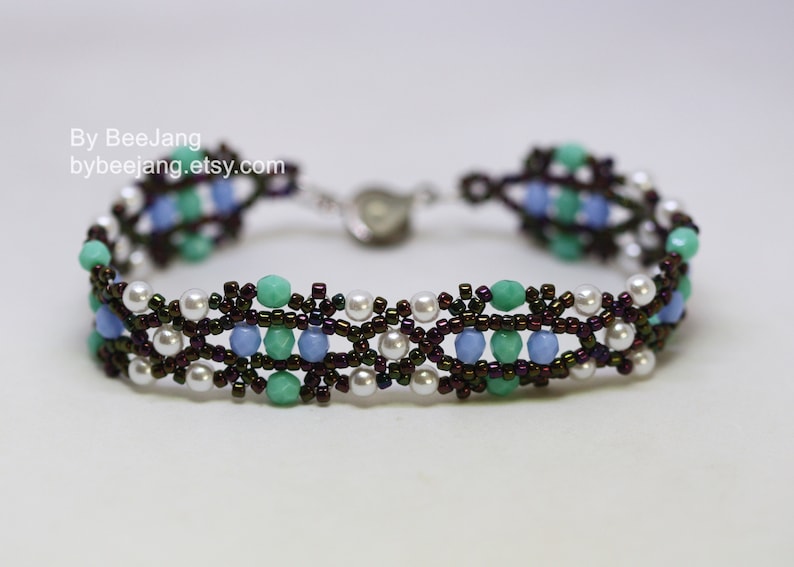 May include: A beaded bracelet with a brown, blue, green, and white color scheme. The bracelet has a clasp closure.