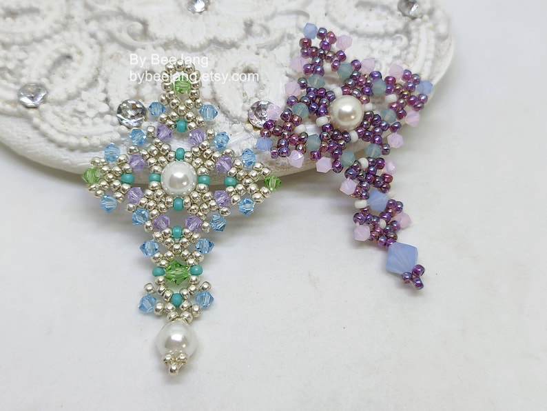 Chrisia pendants in two colors. One is in silver, green peridot and light blue. The other is in purple, blue, pink and pacific opal.