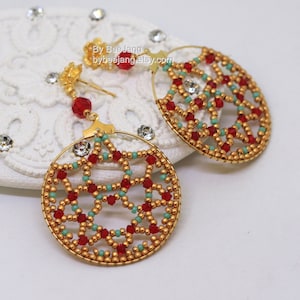 May include: A pair of gold hoop earrings featuring red and turquoise beads. The beads are arranged in a geometric pattern, creating a delicate and intricate design.