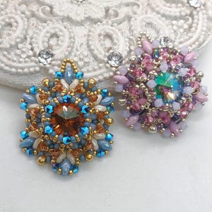 Ceres pendants in two colors. One is in copper, blue and beige. The other is in pink, purple and silver.