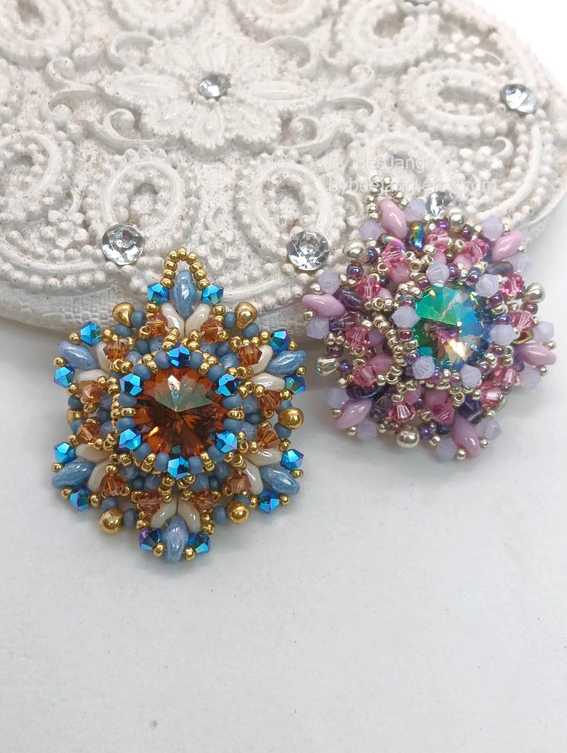 Ceres pendants in two colors. One is in copper, blue and beige. The other is in pink, purple and silver.