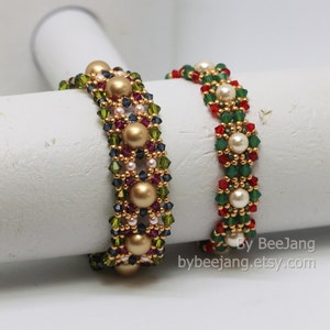 May include: Two beaded bracelets with gold, green, red, and white beads. The bracelets are on a white surface. By BeeJang bybeejang.etsy.com