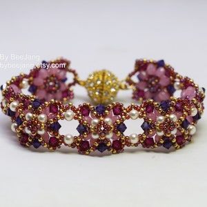 May include: A beaded bracelet featuring pink, purple and gold beads. The bracelet has a magnetic clasp.