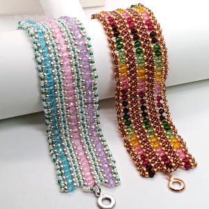 Può includere: Due braccialetti di perline. Uno è un mix di perline blu, rosa e viola con dettagli argentati. L'altro braccialetto presenta un mix di perline rosse, verdi, gialle e dorate. Entrambi i braccialetti hanno una chiusura.