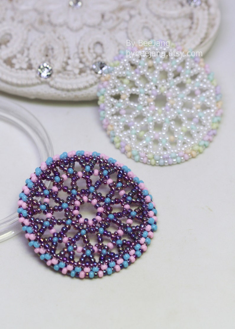 Olwyn wheel pendants in two colors. One is white and mix pastel. The other is purple, pink and blue.