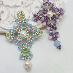 Chrisia pendants in two colors. One is in silver, green peridot and light blue. The other is in purple, blue, pink and pacific opal.