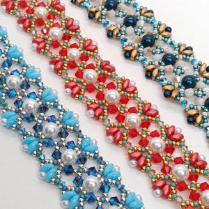 May include: Close-up of three beaded bracelets in red, blue, and gold. Each bracelet features a floral design with pearl accents. The bracelets are made with small beads and crystals, creating a delicate and intricate pattern.
