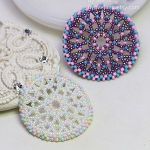 Olwyn wheel pendants in two colors. One is white and mix pastel. The other is purple, pink and blue.