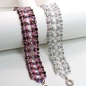 Two wide, handcrafted beaded cuff bracelets are draped over a white stand, showcasing an intricate Right Angle Weave lattice design. Each piece is meticulously woven with faceted bicone crystals, smooth round pearls, and delicate seed beads, secured with a metallic toggle clasp.

    Left: Purple and lavender beads accented by dark metallic bronze rounds and a silver clasp.
    Right: Clear crystals with white pearls and a silver clasp.