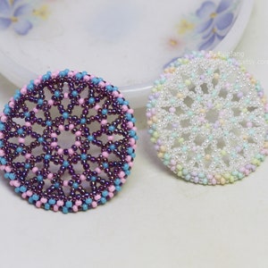 Olwyn wheel pendants in two colors. One is white and mix pastel. The other is purple, pink and blue.