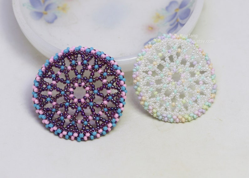 Olwyn wheel pendants in two colors. One is white and mix pastel. The other is purple, pink and blue.
