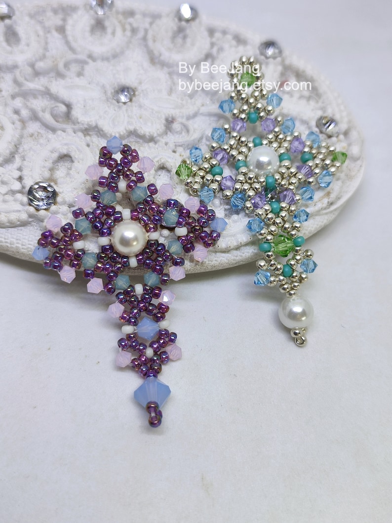 Chrisia pendants in two colors. One is in silver, green peridot and light blue. The other is in purple, blue, pink and pacific opal.