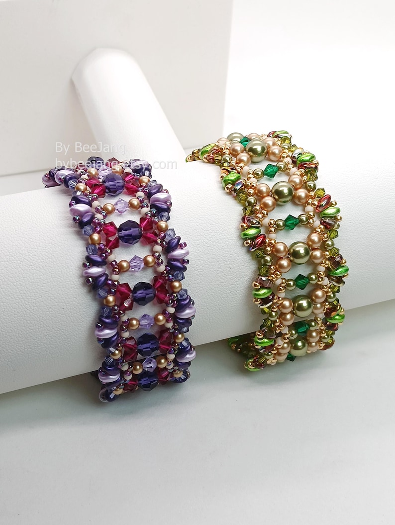 Puede incluir: Dos pulseras de cuentas. Una es morada, burdeos y dorada. La otra es verde, dorada y roja. Las pulseras est&aacute;n hechas de peque&ntilde;as cuentas y se exhiben sobre una superficie blanca.