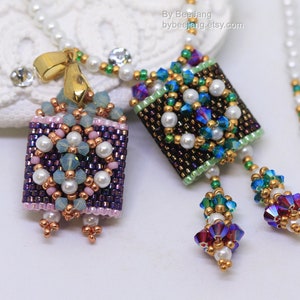 May include: Two beaded square pendants with gold accents and pearl details. The pendants are attached to a white pearl necklace with gold accents. The pendant on the left is purple, pink, and blue. The pendant on the right is green, blue, and brown. The necklace is labelled "By Bee Jang bybeejang.etsy.com".
