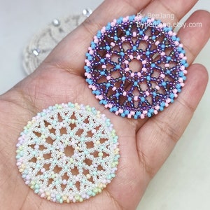 Olwyn wheel pendants in two colors. One is white and mix pastel. The other is purple, pink and blue.