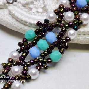 May include: A close-up of a beaded bracelet with a multi-strand design. The bracelet features brown iridescent beads, white pearls, and turquoise and light blue faceted beads. The bracelet is on a white surface.