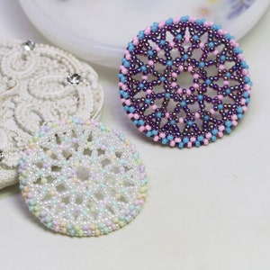 Olwyn wheel pendants in two colors. One is white and mix pastel. The other is purple, pink and blue.