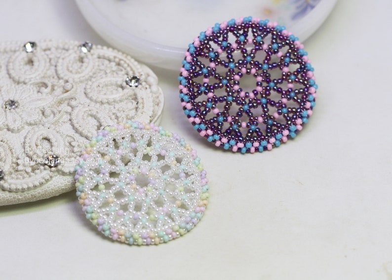 Olwyn wheel pendants in two colors. One is white and mix pastel. The other is purple, pink and blue.