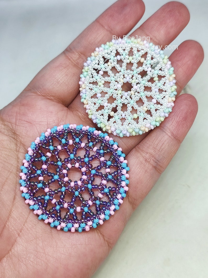 Olwyn wheel pendants in two colors. One is white and mix pastel. The other is purple, pink and blue.