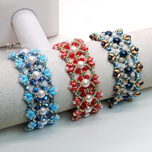 May include: Three beaded bracelets in blue, red, and gold. The bracelets feature pearls and various beads, forming a floral pattern. The bracelets are displayed on a white cylindrical form.