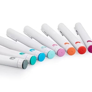 Puede incluir: Un conjunto de bolígrafos blancos con detalles coloridos. Cada bolígrafo tiene un cuerpo blanco y una tapa de color, incluyendo turquesa, azul, rosa, naranja, rojo y morado. Los bolígrafos están dispuestos en diagonal sobre un fondo blanco.