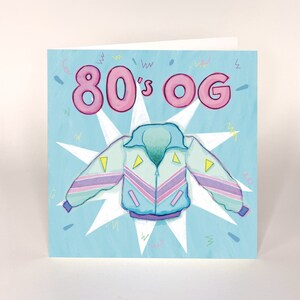 May include: A blue and pink 80's style jacket with a white starburst background and the text "80's OG".