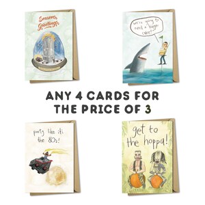 May include: Four greeting cards with illustrated designs. The cards feature a snow globe with a city inside, a shark with a man holding a cake, a monster truck with a person driving, and two people riding on pumpkins. The text on the cards reads "Seasons Greetings", "We're going to need a bigger cake!", "Party like it's the 80's!" and "Get to the hoppa!" The text "ANY 4 CARDS FOR THE PRICE OF 3" is displayed below the cards.