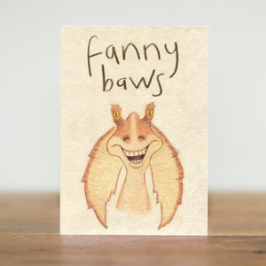 May include: A greeting card with a cartoon illustration of a character from Star Wars. The character is smiling and the text on the card says "Fanny Baws".