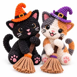 Könnte beinhalten: Zwei gehäkelte Katzenfiguren, eine schwarze und eine dreifarbige, tragen jeweils einen spitzen Hexenhut und halten einen kleinen braunen Besen. Die schwarze Katze trägt einen orangefarbenen Hut, die dreifarbige einen lila Hut. Große schwarze Augen und rosa Pfoten.