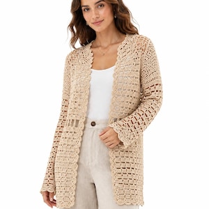 May include: A beige open-front cardigan featuring an intricate crochet pattern with a scalloped edge along the neckline and front opening. The long-sleeved garment has a semi-sheer, grid-like texture throughout, providing a lightweight layer.