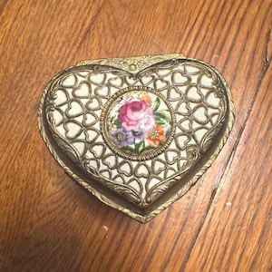 Könnte beinhalten: Ein Set aus drei Keramikbechern mit gesprenkelter, matter Oberfläche. Die Becher sind in Creme-, Hellgrau- und Dunkelgrautönen gehalten. Jeder Becher hat ein schlichtes, modernes Design und einen abgerundeten Henkel.