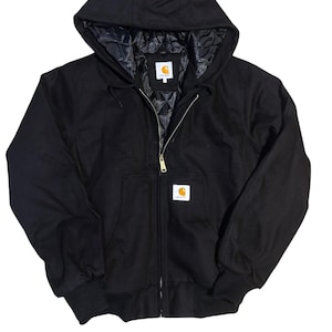 Könnte beinhalten: Schwarze Kapuzenjacke mit Reißverschluss und Vordertasche. Die Jacke hat ein gestepptes Futter und ein kleines weißes quadratisches Logo auf der Brust und der Kapuze. Sie hat gerippte Bündchen und eine Kapuze mit Kordelzug.