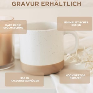 May include: A set of three ceramic mugs with a speckled, matte finish. The mugs are in shades of cream, light gray, and dark gray. Each mug has a simple, minimalist design and a rounded handle.
